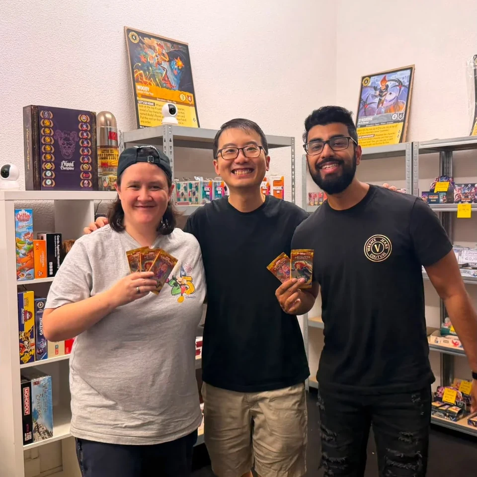 Three players showing trading cards in the store