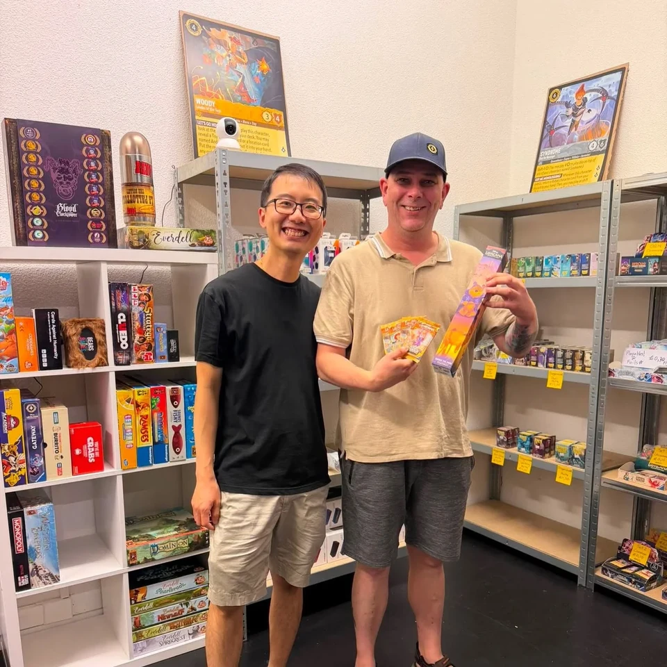 Two players showing trading cards in the ShibeTCG store
