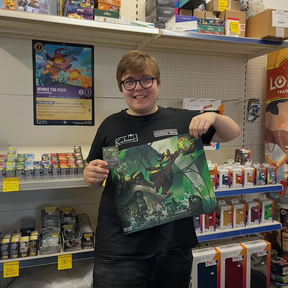 A player holding a Disney Lorcana playmat in the store