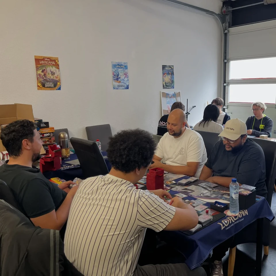 Players enjoying card games around a table in the ShibeTCG store